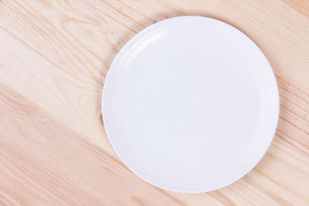 Empty white plate on wooden backgroundの写真素材