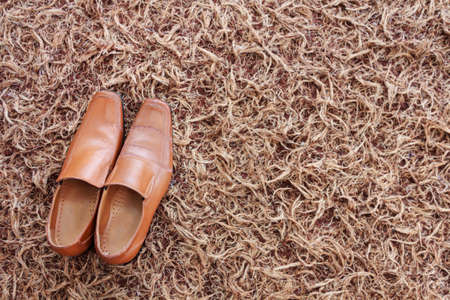 Man brown leather shoes on the carpeted floor for backgroundの写真素材