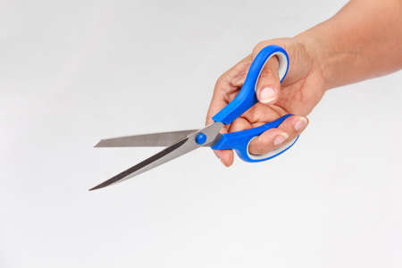 woman's hand holding  scissors on white background.の写真素材