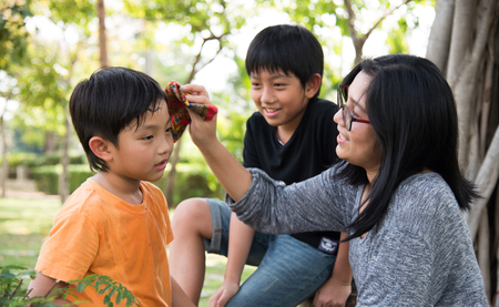 asian family take care happy sweat park mother son boy outdoorの写真素材