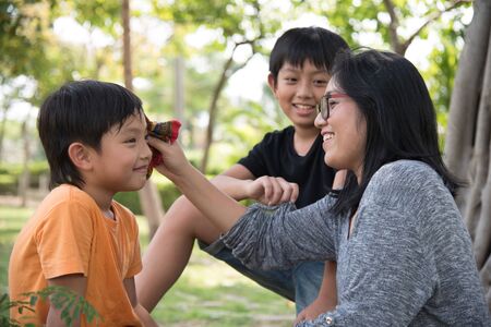 asian family take care happy sweat cute park mother son boy outdoorの写真素材