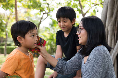 asian family take care park son mother outher boyの写真素材