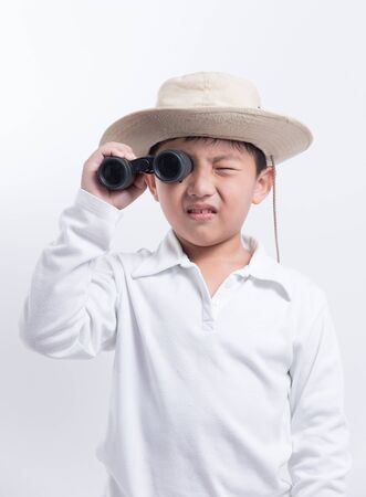 asian boy looking binoculars kid explorer travel portrait hatの写真素材
