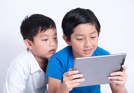 asian boy play tablet mobile kid digital technology indoorの写真素材