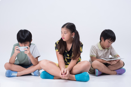 asian kids playing tablet phone kids online young children bored girl boy socialの写真素材