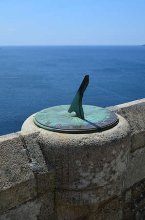 Ornate sundial on sea wall 