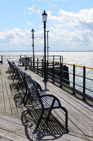 Iron benches on a Victorian pleasure pier in Englandの写真素材