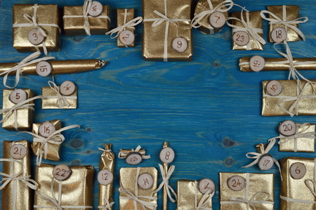Frame of advent calendar with twenty four golden presents on teal woodの写真素材