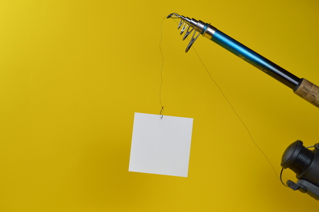 a blank piece of paper at the fishhook of an angling rodの写真素材