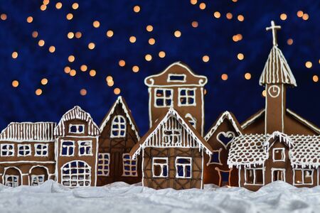 Home made gingerbread town with church and bokeh sky out of blue velvet and christmas lightsの写真素材