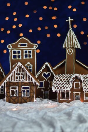 Home made gingerbread town with church and bokeh sky out of blue velvet and christmas lightsの写真素材