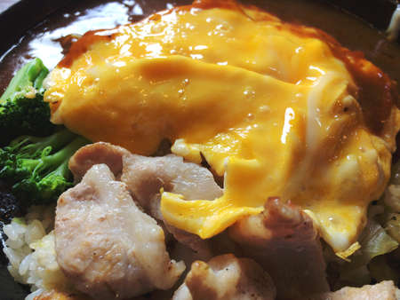 omurice with pork, broccoli and Japaese curry sauce on the hot place / Japanese traditonal foodの写真素材