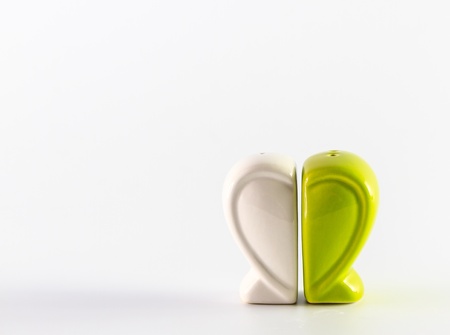 Green heart containers for salt and pepper isolated on whiteの写真素材