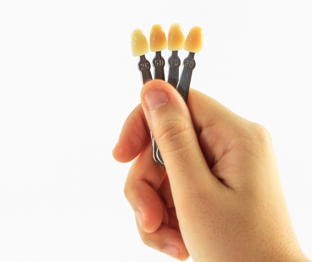 woman hand with shade guide teeth isolated on white backgroundの写真素材