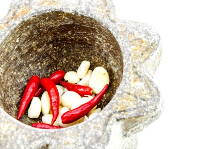 garlic and red chili pepper in stone mortarの写真素材