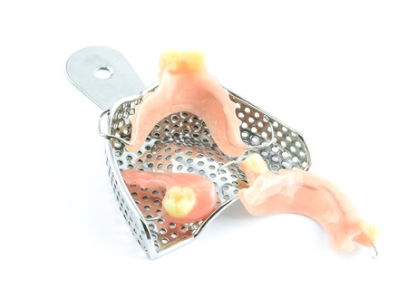 Trays with dentures on white background