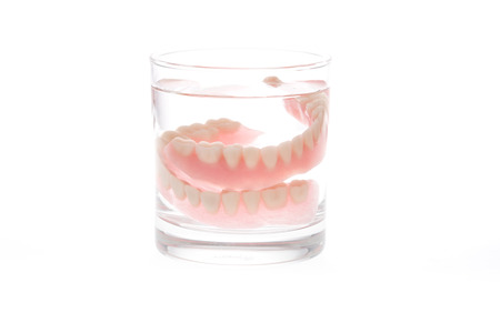 Full Denture in glass of water on white backgroundの写真素材