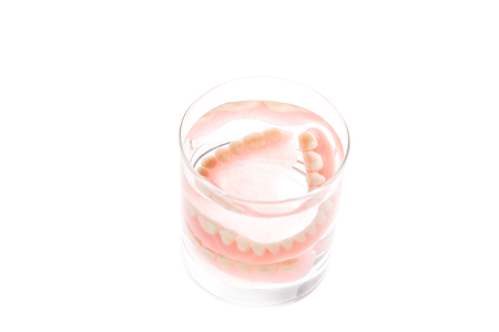 Full Denture in glass of water on white backgroundの写真素材