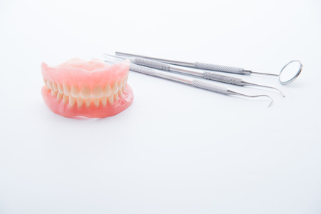 Denture and dental tools,dental mirror on white background