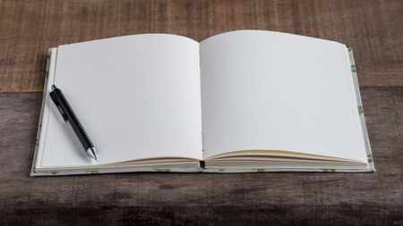 Closeup of opened handmade book and pencil on wooden backgroundの写真素材