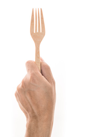 Men hand holding wooden fork on white backgroundの写真素材