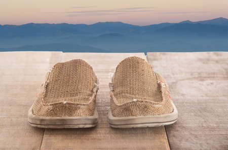 Sneakers on wooden with the mountain view and cloudy skyの写真素材