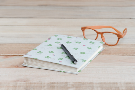 book and pen,eyeglass on wood tableの写真素材
