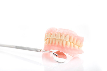Tatar on dentures and dental mirror pn white background