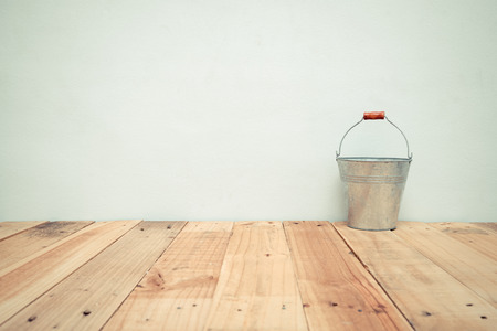 Vintage zinc bucket on wooden table and cement wall backgroundの写真素材