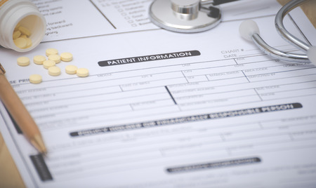 Close-up of patient information concept,Stetoscope and medicine,pen on patient form on the desk.の写真素材