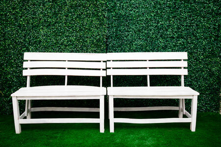 White chairs and a backdrop of green grass.の写真素材
