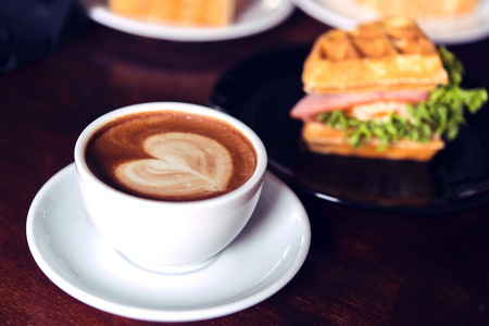 coffee mocha hot and Ham and cheese sandwich on wooden tableの写真素材