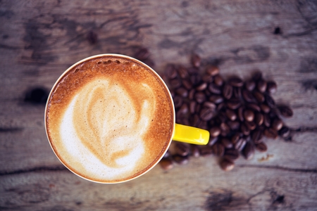 coffee mocha hot and coffee beans on wooden table on brown backgroundの写真素材