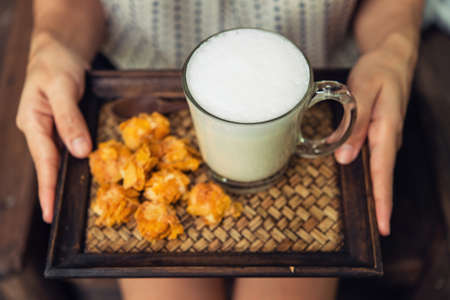 Woman holding a glass of hot milk sitting  relax in a coffee shop.の写真素材