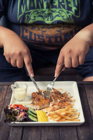 fat Man holding pork steak In a coffee shopの写真素材