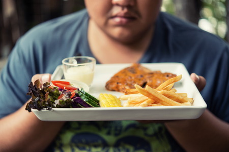 fat Man holding pork steak In a coffee shopの写真素材