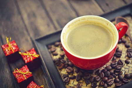 Coffee cup and christmas redbox decoration on wooden table backgroundの写真素材