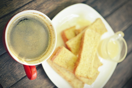 woman holding hot cup of coffee,on table wooden bgの写真素材