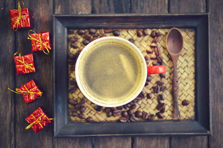 Coffee cup and christmas redbox decoration on wooden table backgroundの写真素材
