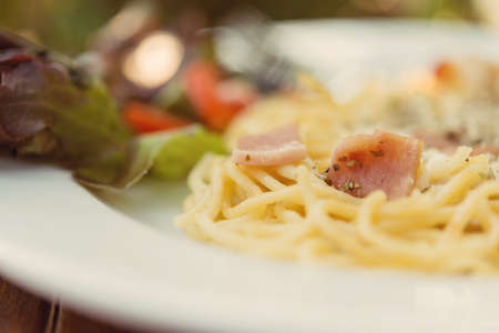 The spaghetti white sauce with bacon on a wooden table.の写真素材