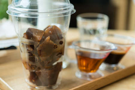 Ice  coffee and Coffee and syrup on a wooden table in a coffee shop.の写真素材