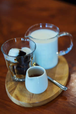 Ice  coffee and Coffee and syrup on a wooden table in a coffee shop.の写真素材