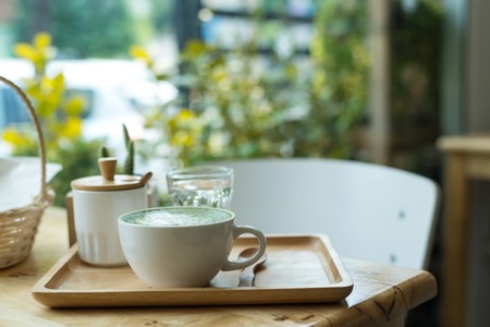 Hot green tea set on a wooden table in a coffeshopの写真素材