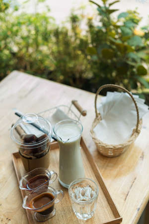 Ice  coffee and Coffee and syrup on a wooden table in a coffee shop.の写真素材