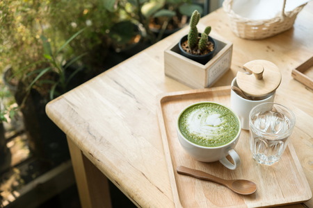 Hot green tea set on a wooden table in a coffeshopの写真素材