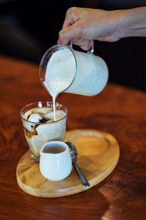 Woman holding Ice coffee and Coffee  in a coffee shop in holidaysの写真素材