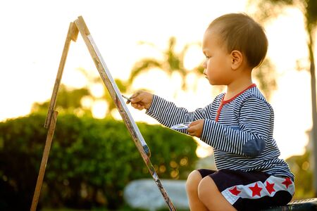 child  painting color drawing at public park is sunsetの写真素材