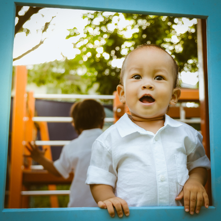 Asian boy playing in the playground in the parkの写真素材