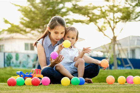 happy mom and 2boy having fun Playing ball on the lawn. in holiday at time sunsetのeditorial素材