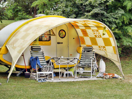 Caravan at camping site,  table and empty chairs in front ofの写真素材